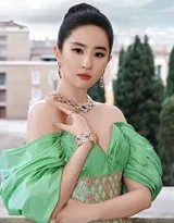 刘亦菲背对镜头回眸凝望，绿色长裙的露背设计展现优美蝴蝶骨，回眸瞬间眼神清澈而极具穿透力，仿佛与观众进行一场无声的灵魂交流