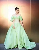 刘亦菲置身于罗马庭院光影交错处，正面迎向镜头，深V绿裙尽显自信与大气，身后拱门与绿植构成天然画框，她宛若一幅珍藏于美术馆的当代肖像名作
