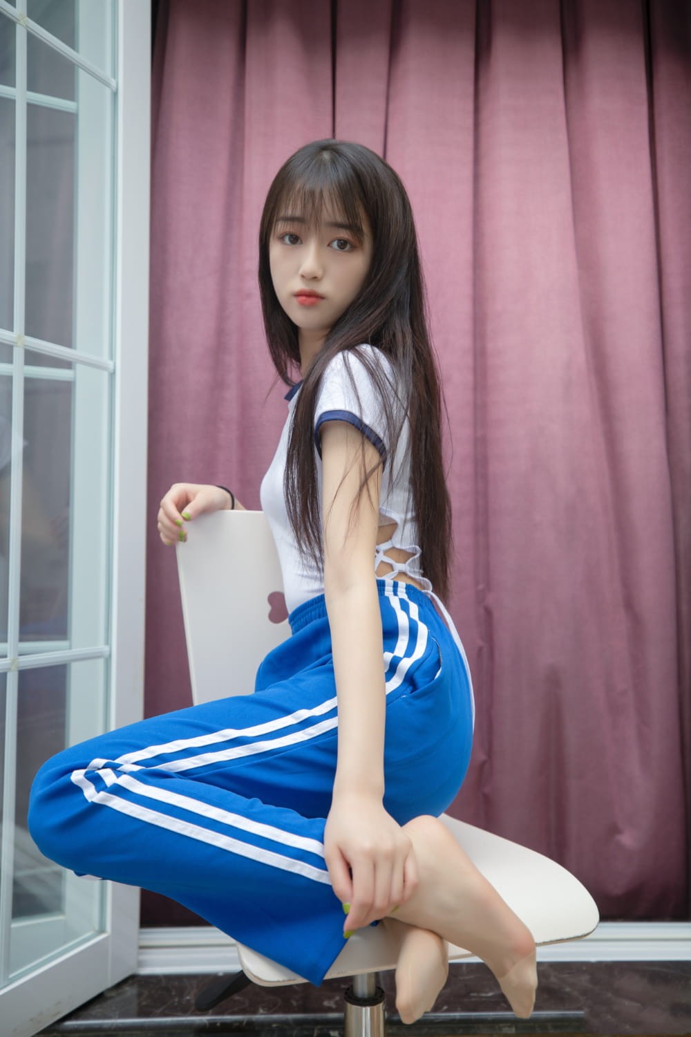 扎着柔顺马尾的女生侧身回眸，阳光下发丝被染成金色，眼眸清澈含着浅浅笑意