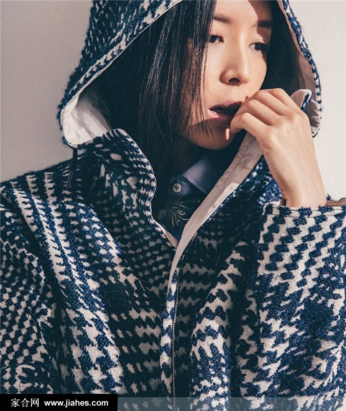 张静初漫步于灰色阶梯，黑色上衣与红色手袋形成视觉焦点，步伐轻盈自在
